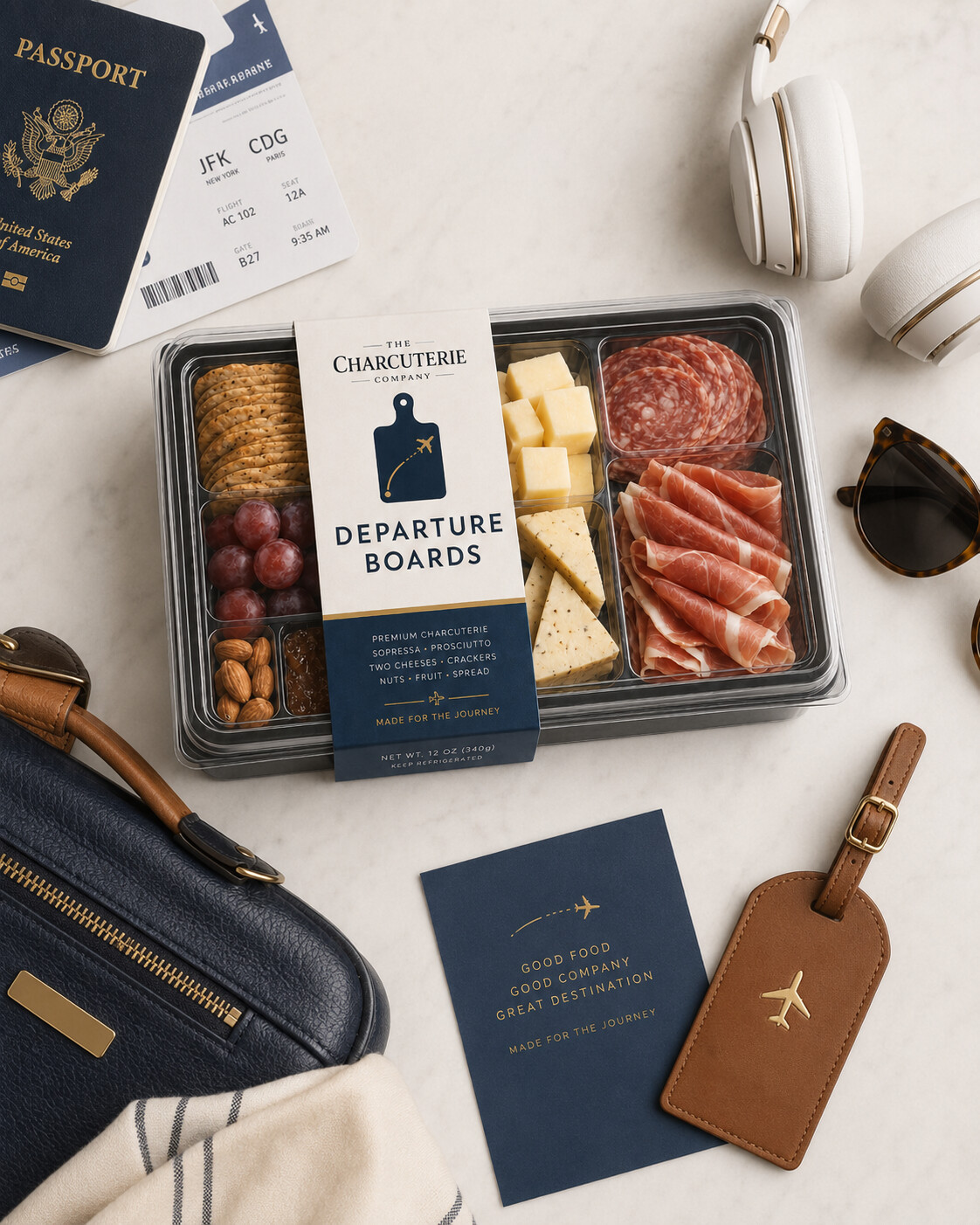 Concept packaging for Departure Boards: a labelled charcuterie tray beside a passport, boarding pass, headphones, and luggage tag